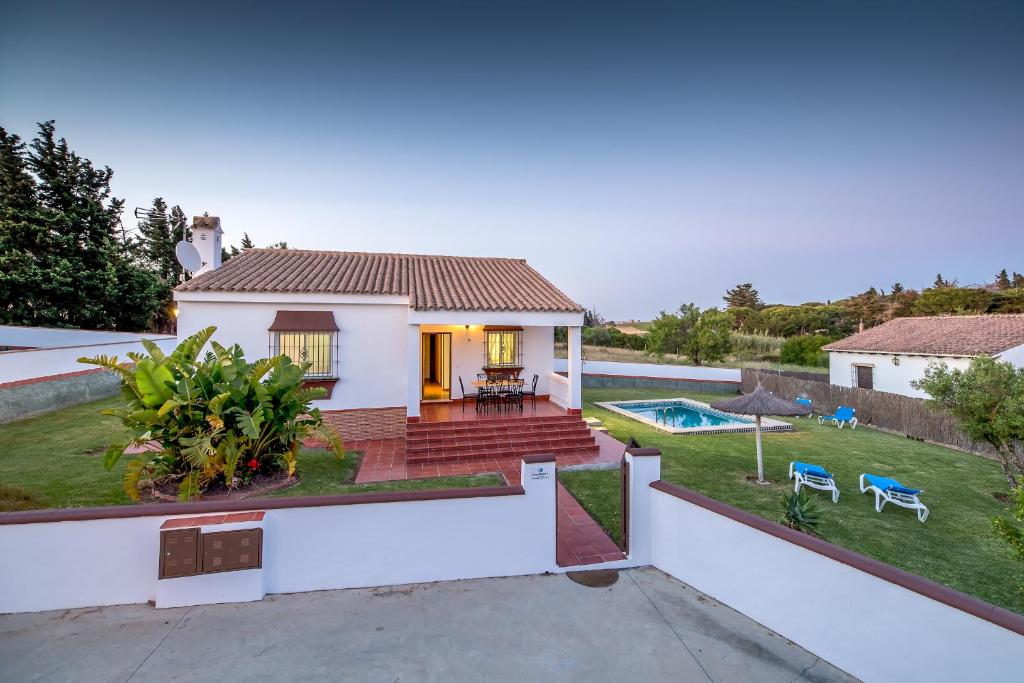 a white house with a yard and a swimming pool at Chalet Miriam II in Conil de la Frontera