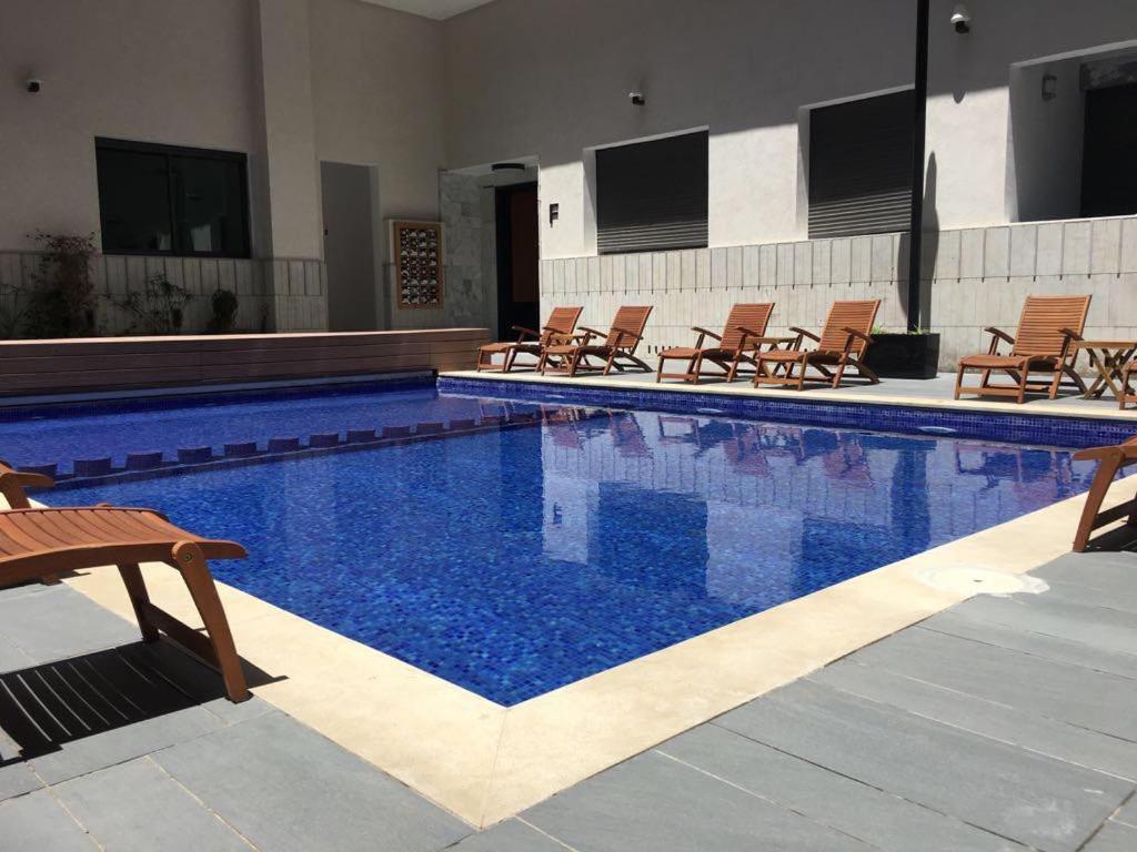 a swimming pool with chairs and a swimming pool at Appartement Miramar in Mohammedia