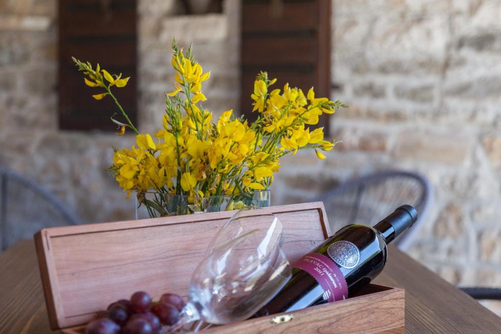 una bottiglia di vino su un tavolo con un vaso di fiori di Kuća za odmor Aurora a Kavran