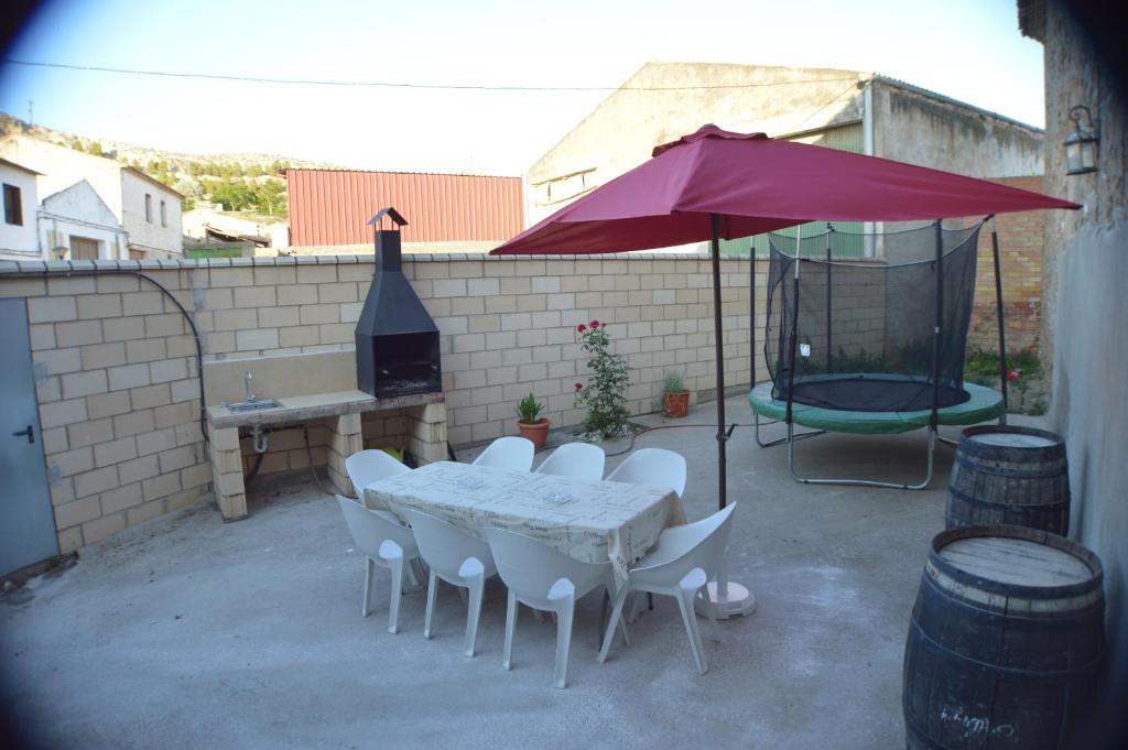 un patio con mesa, sillas y sombrilla en Casa Rural El Convento, en Valtierra