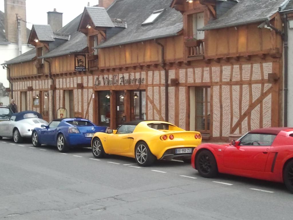 a row of parked cars parked in front of a building at LAUBERG;APPART in Cour-Cheverny