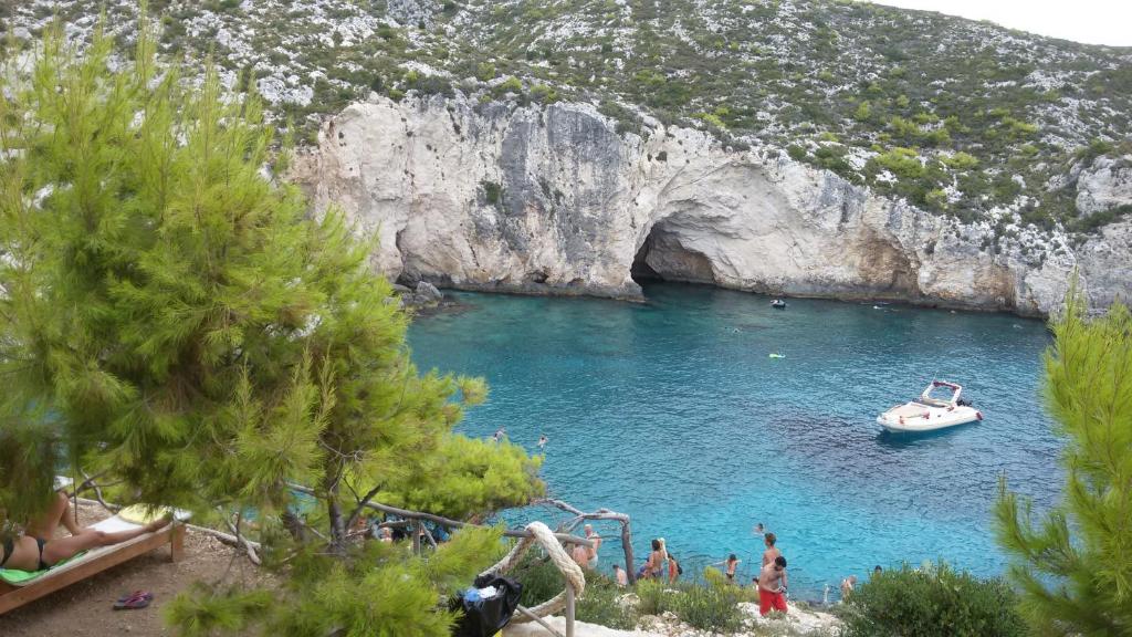 a boat in a cave with people in the water at STERNES house in Agios Leon