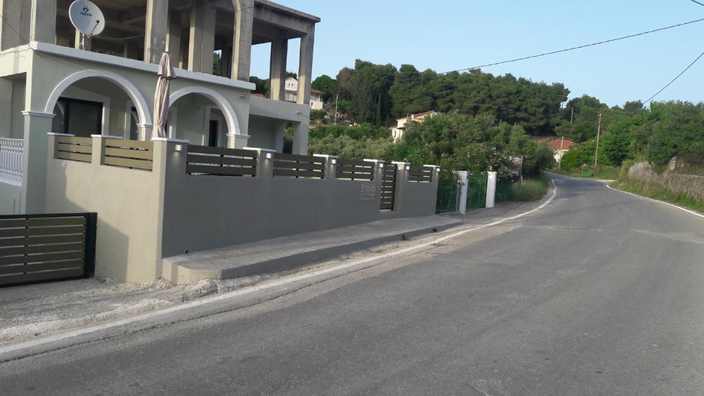 an empty road next to a building with a fence at STERNES house in Agios Leon