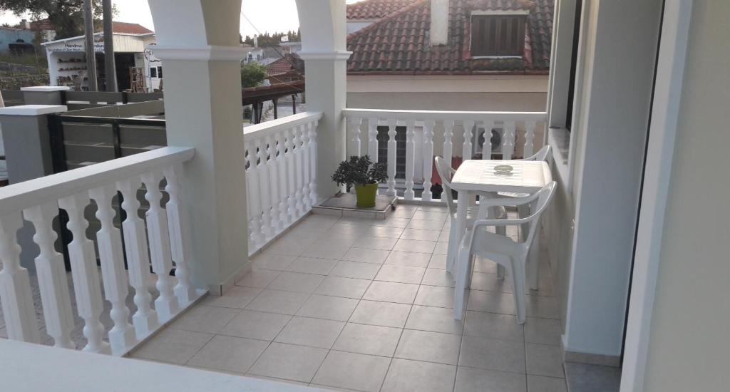 a white balcony with a table and a stool at STERNES house in Agios Leon