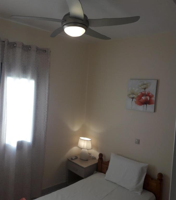 a bedroom with a bed and a ceiling fan at STERNES house in Agios Leon