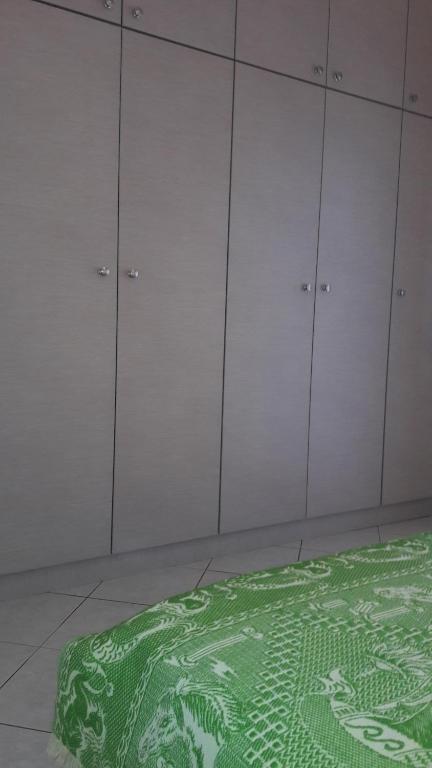 a room with white hangers and a green rug at STERNES house in Agios Leon