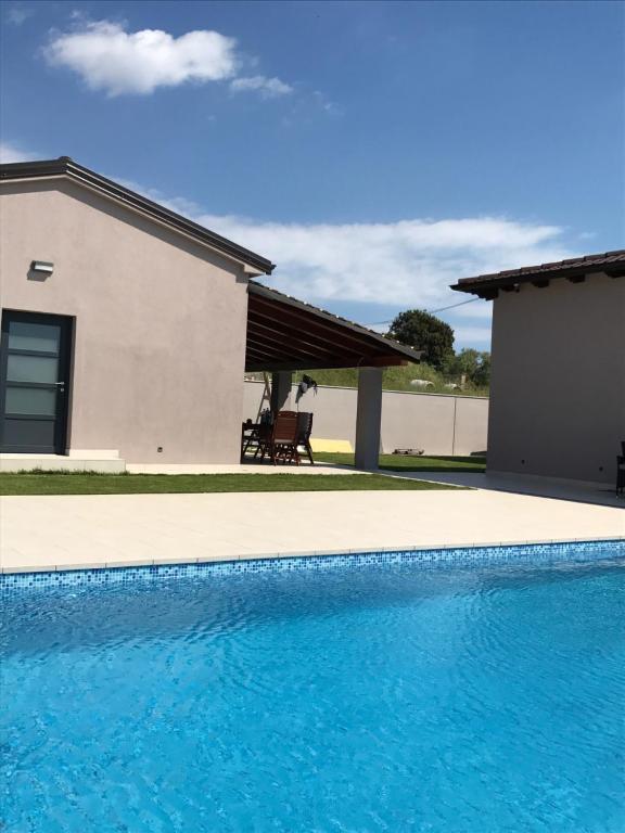 a swimming pool in front of a house at Small house Tia with private pool in Pula