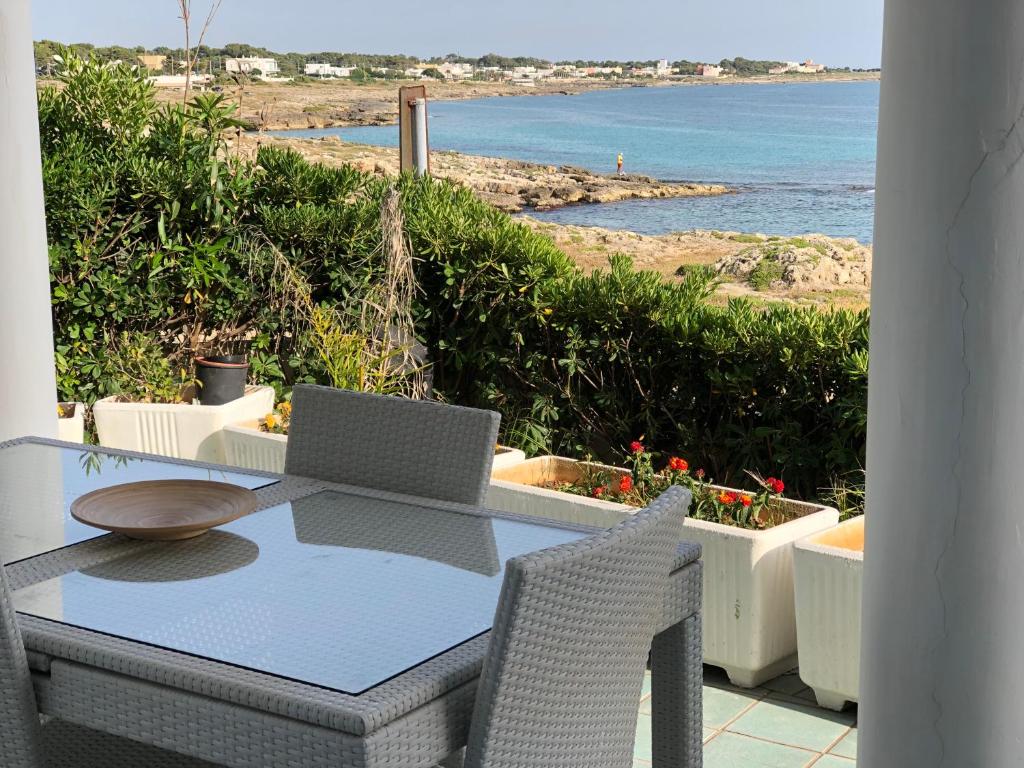 un tavolo con computer portatile in cima a un balcone di Casa direttamente sul mare 1 a Marina di Mancaversa