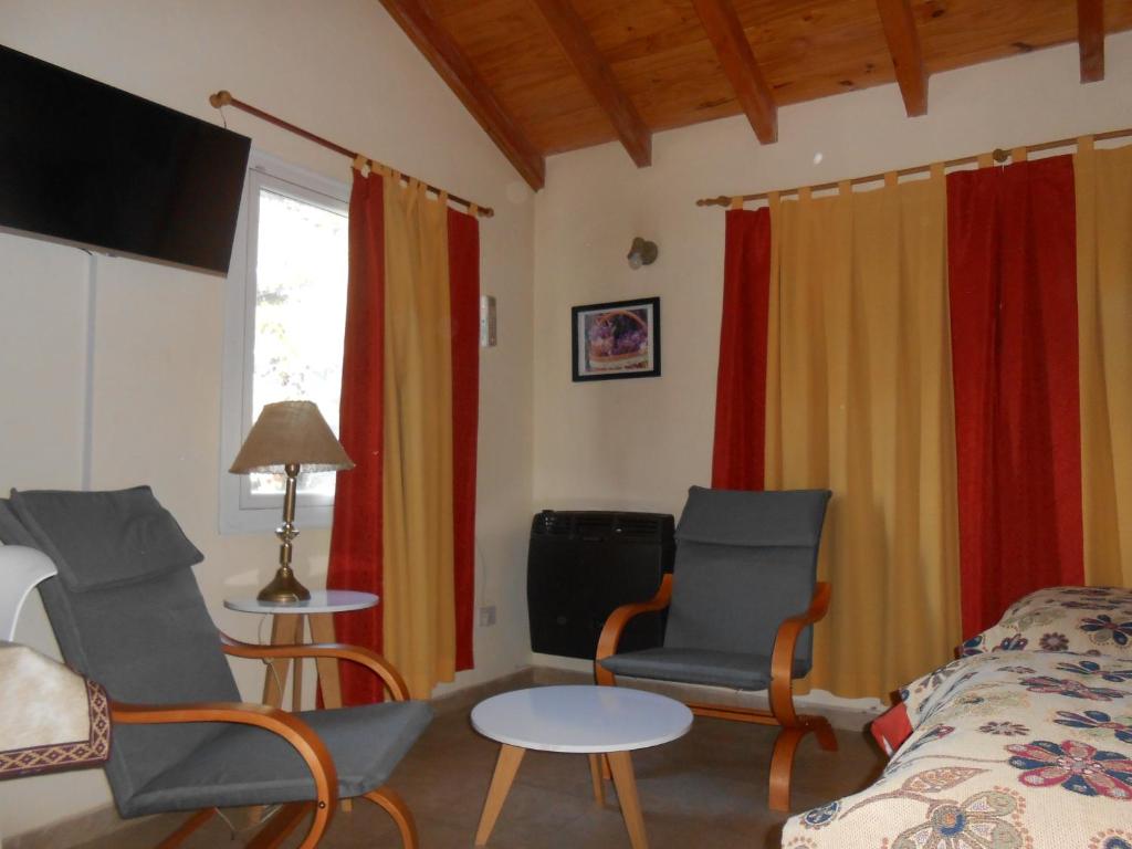 een kamer met een bed en twee stoelen en een tafel bij Montalto in Dina Huapi