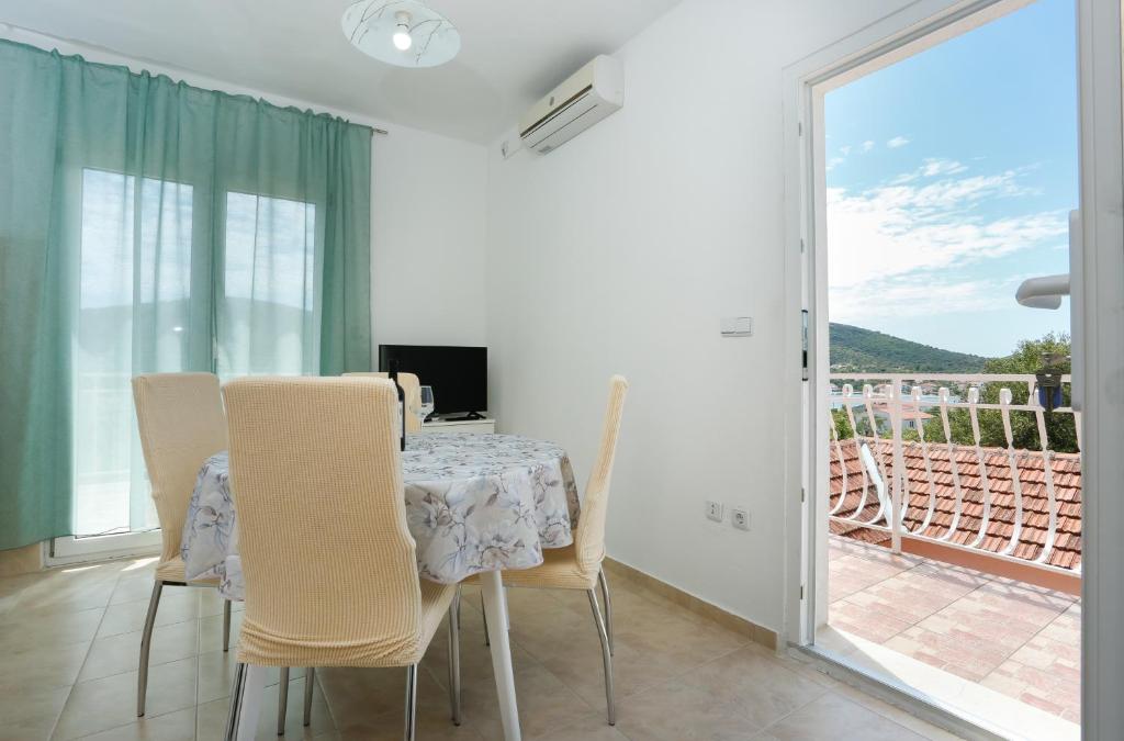 uma sala de jantar com mesa e cadeiras e uma varanda em Apartman Paula 1 em Vinišće