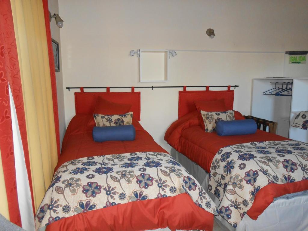 a bedroom with two beds with red comforters at Montalto in Dina Huapi
