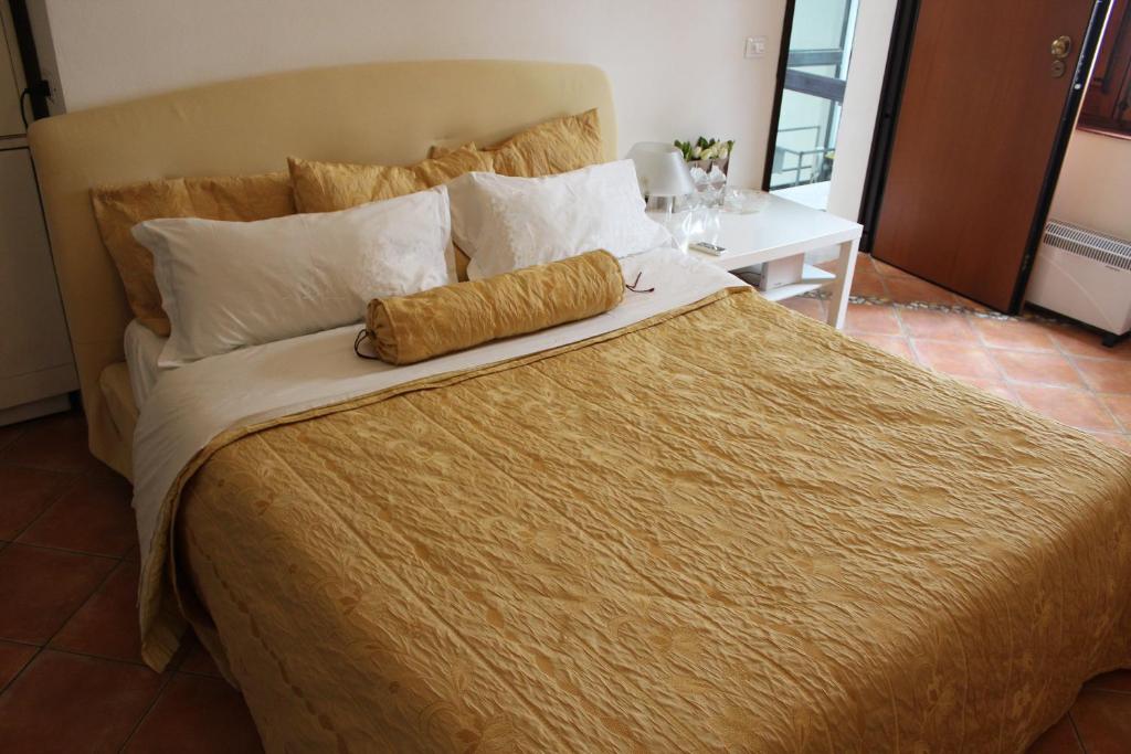 a large bed with a gold blanket and pillows at Home Resuttano in Palermo