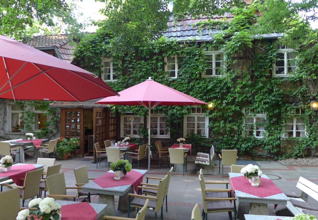 un patio con mesas y sombrillas frente a un edificio en Gasthof Bad Hopfenberg en Petershagen