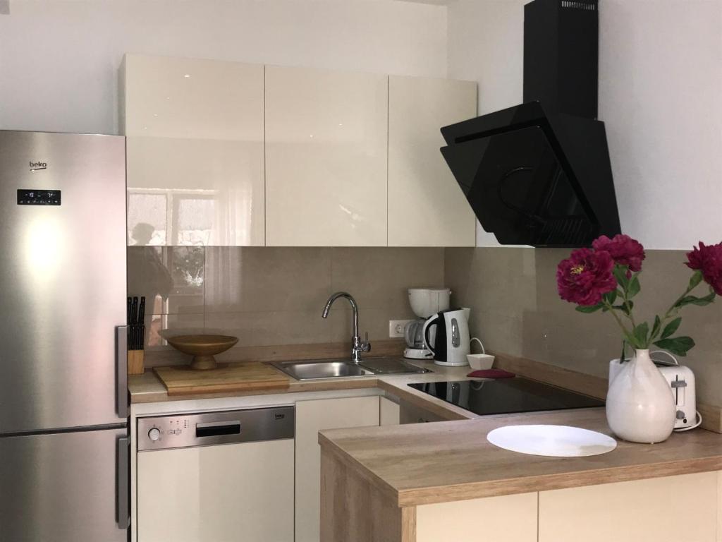 a kitchen with white cabinets and a stainless steel refrigerator at Apartments Jani in Hvar