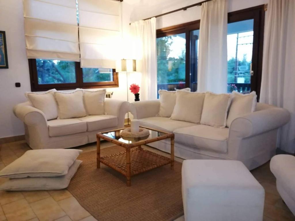 a living room with white couches and a table at Seagull Villa Chalkidiki in Pefkohori