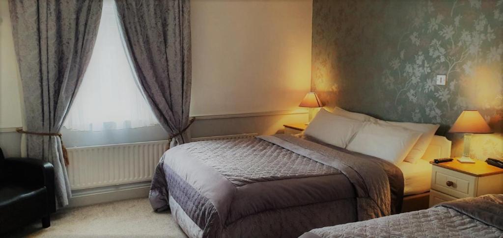 a hotel room with two beds and a window at Danagher’s Hotel Cong in Cong