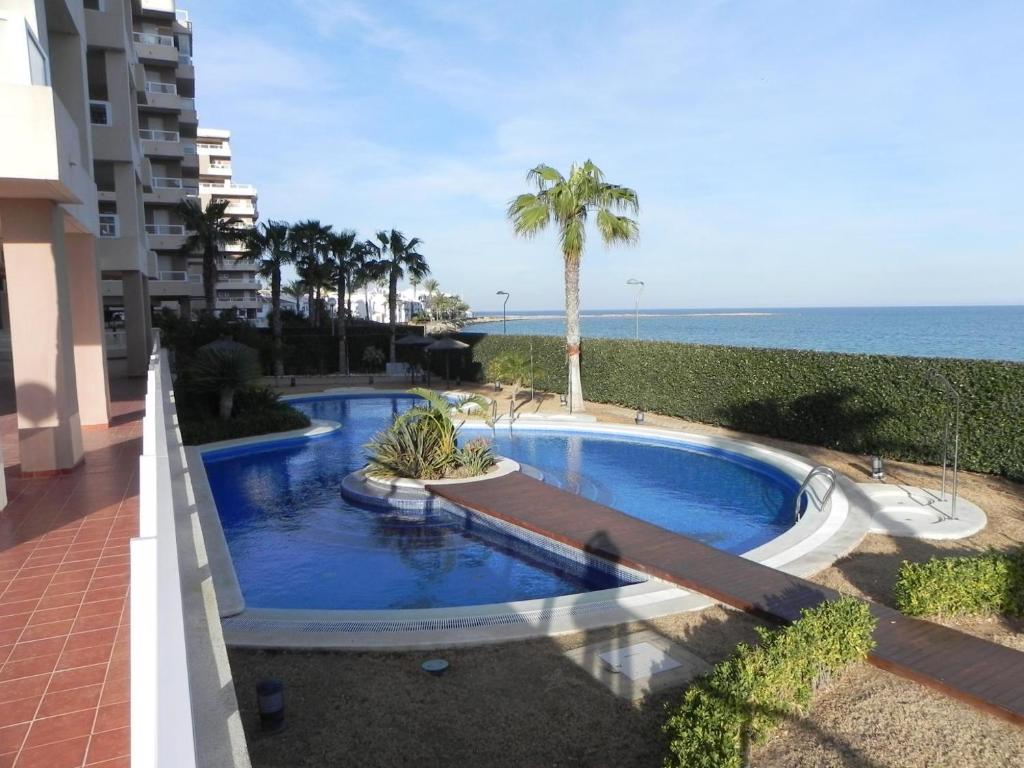 una piscina frente a un edificio con el océano en Punta Cormoran en La Manga del Mar Menor