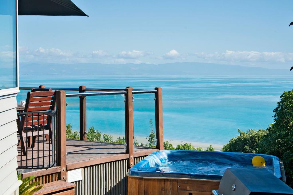 bañera de hidromasaje en una terraza con vistas al océano en Selah Retreat en Nelson