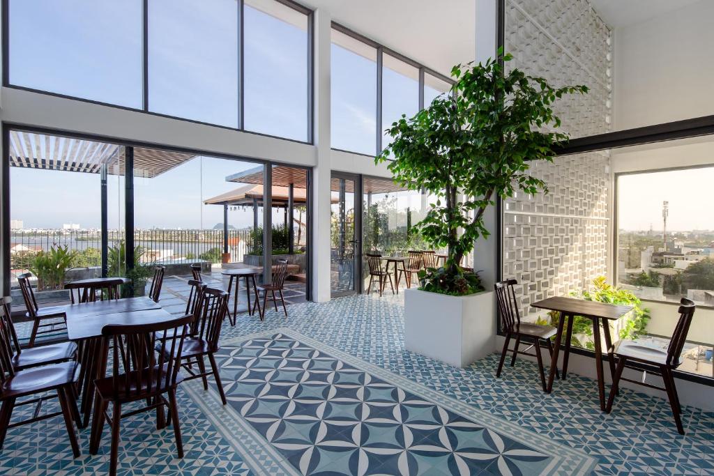 a restaurant with tables and chairs and a potted plant at An An Homes in Danang