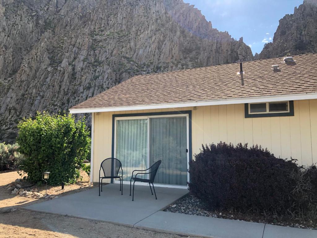 a house with two chairs sitting outside of it at Meadowcliff Lodge Coleville in Coleville