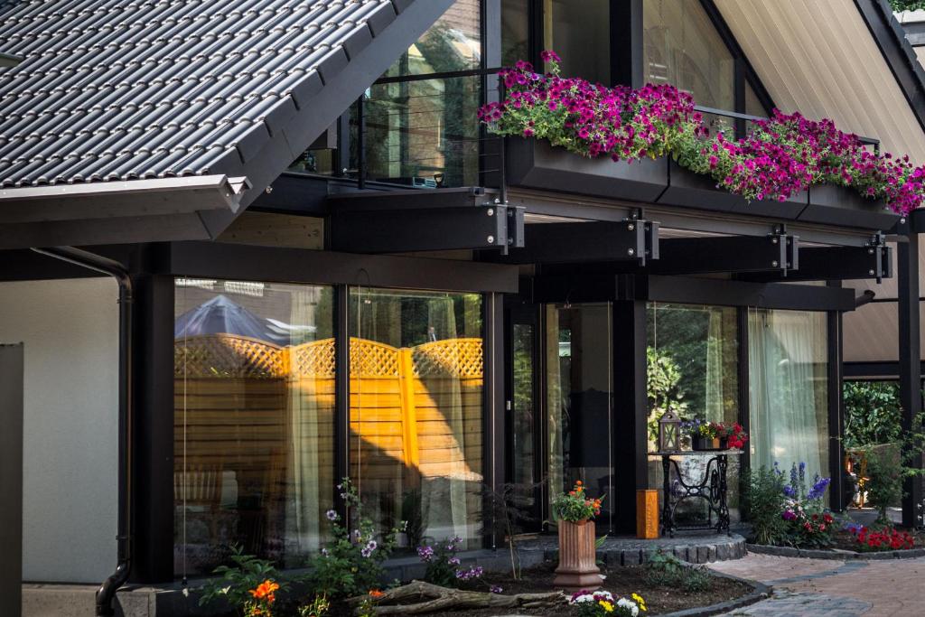 a building with windows and flowers in a courtyard at Vivere Ad Parcum - Bed And Breakfast in Krefeld