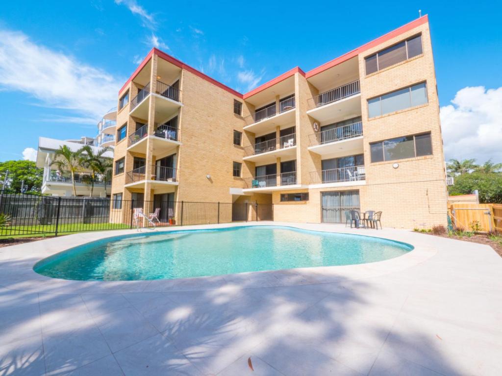 a swimming pool in front of a apartment building at Golden Shores Unit 3 21 Landsborough Parade in Caloundra