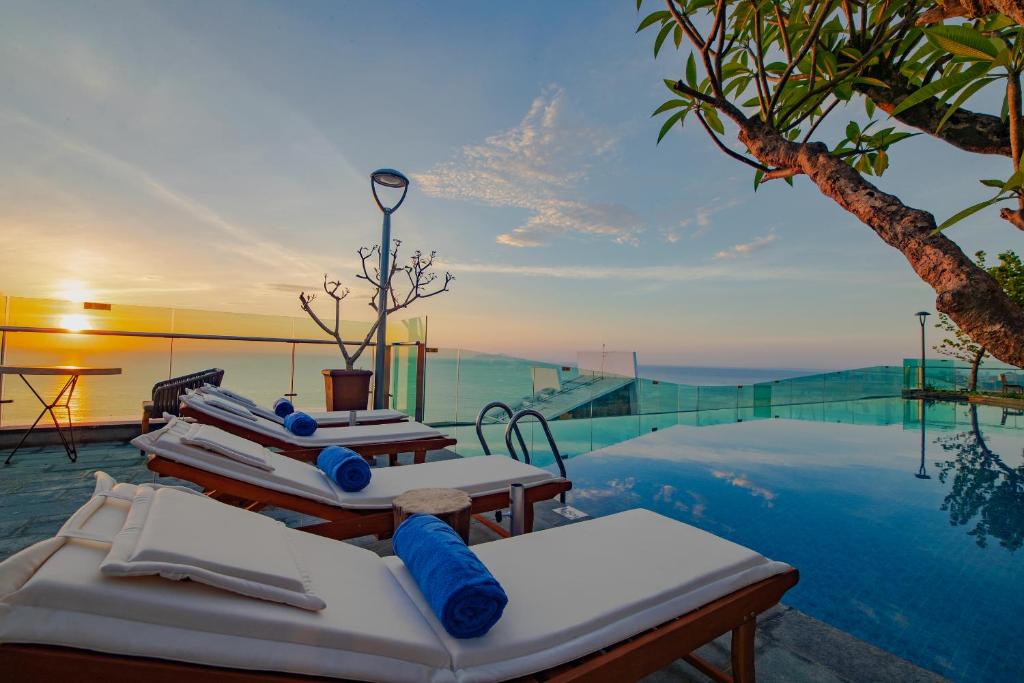 An infinity-style pool terrace with loungers facing the sea.