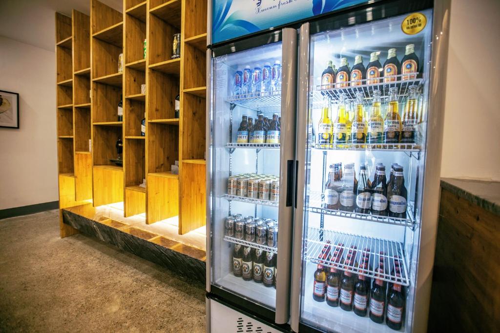 a refrigerator filled with lots of bottles of alcohol at Whispering Mountains Boutique Hotel in Zhangjiajie
