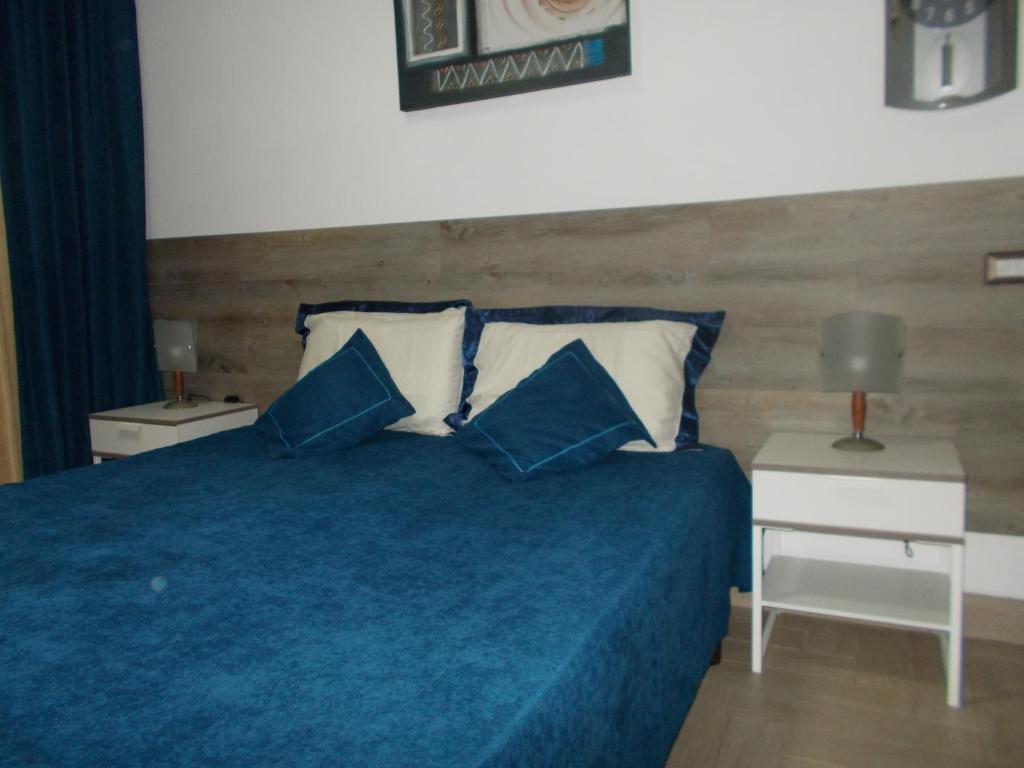 een slaapkamer met een blauw bed met 2 blauwe kussens bij Milla's house rome in Rome