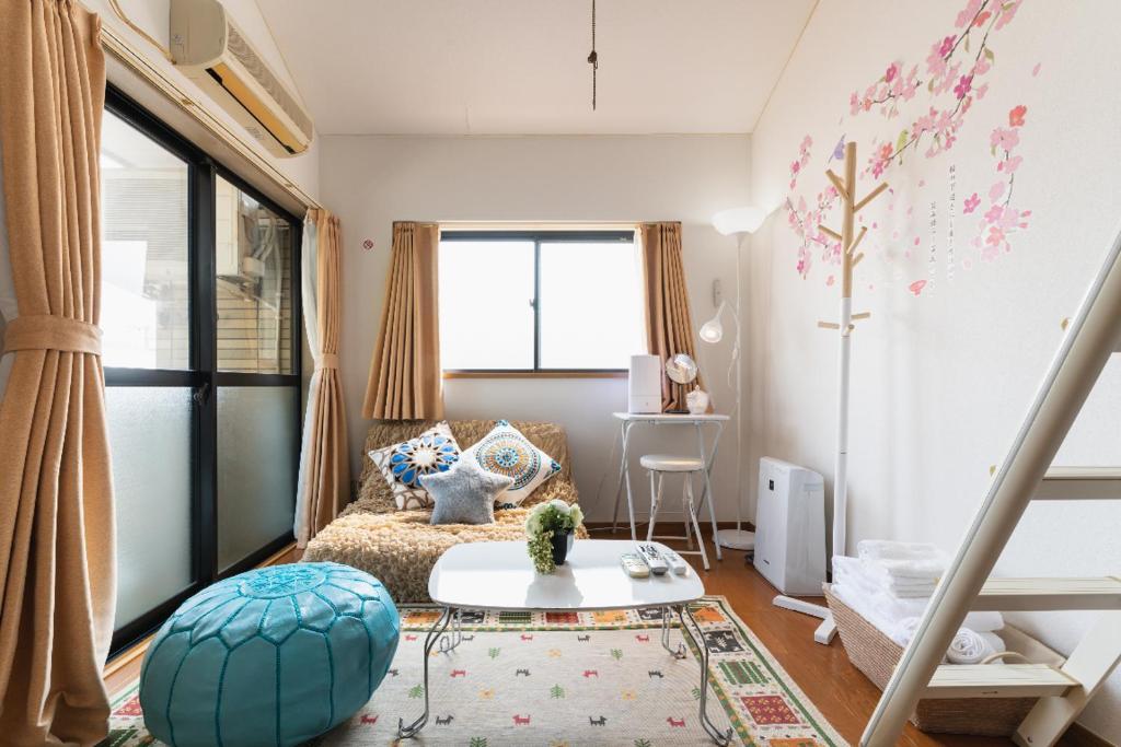 福岡市にあるROOMs六本松03の小さなリビングルーム(ベッド1台、テーブル付)