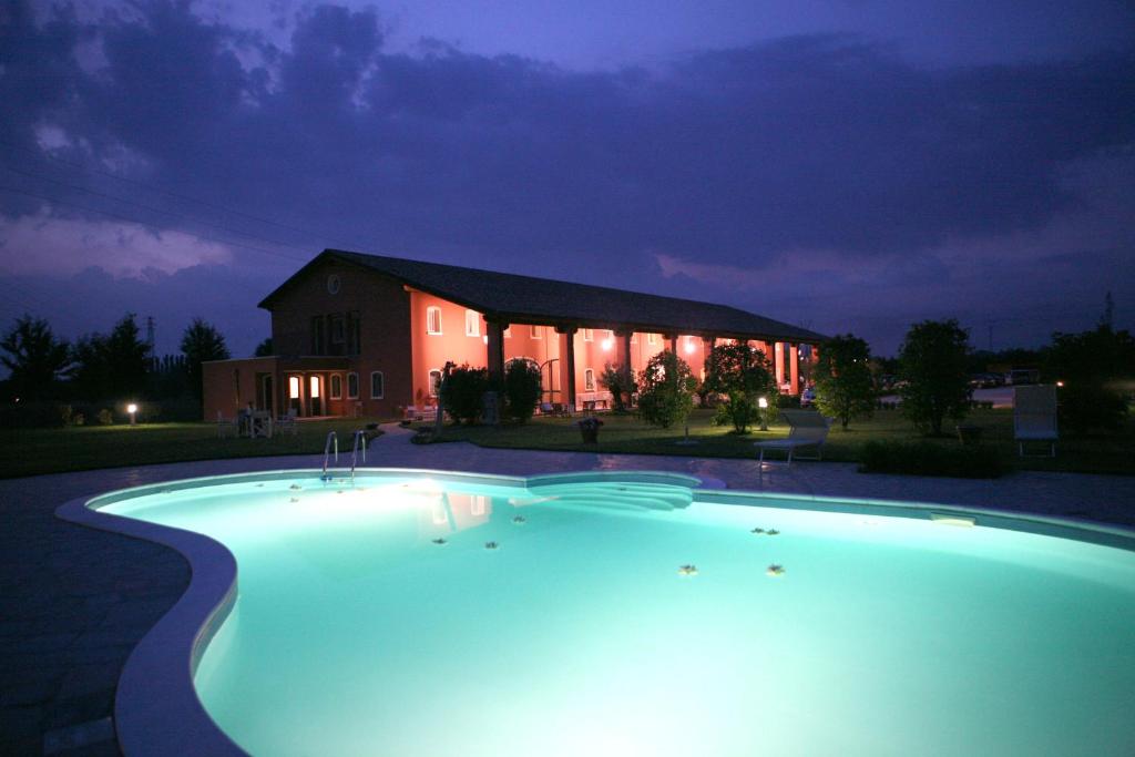 a large swimming pool in front of a house at night at Tenuta Monterosso in Feriole