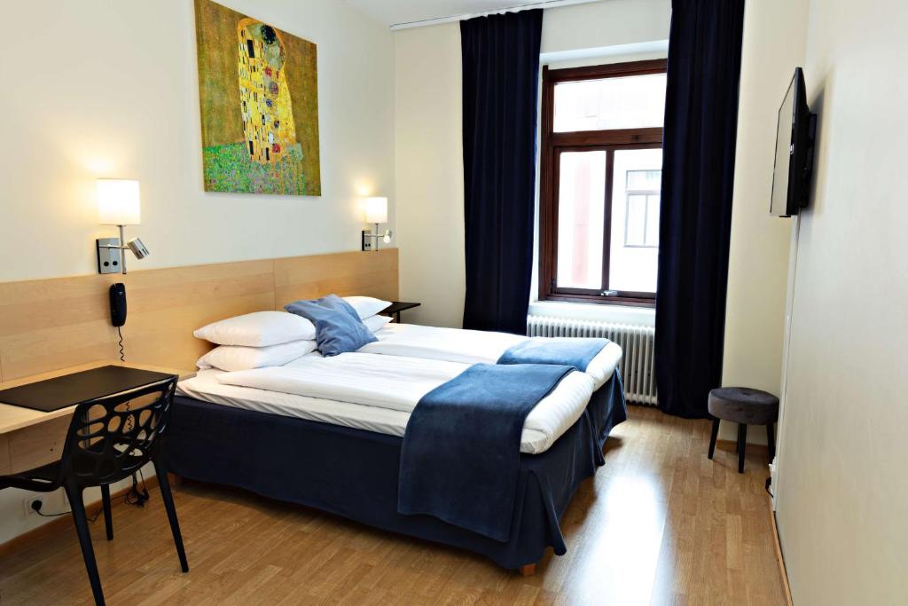 1 dormitorio con cama, escritorio y ventana en Center Hotel- Sure Hotel by Best Western Center, en Gotemburgo