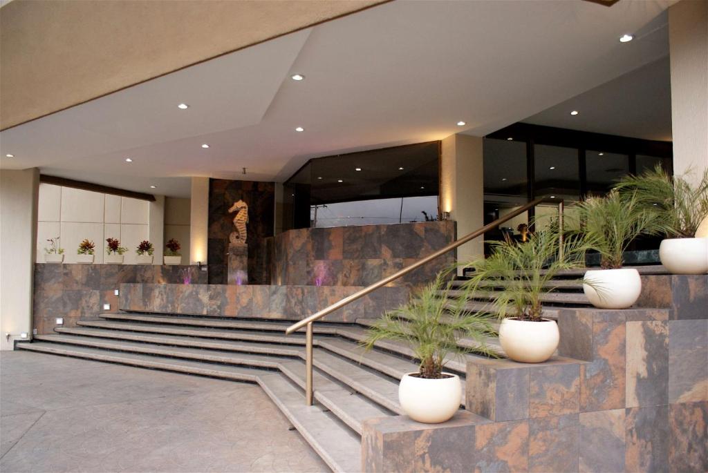 a lobby of a building with stairs and potted plants at Best Western PLUS Plaza Florida & Tower in Irapuato