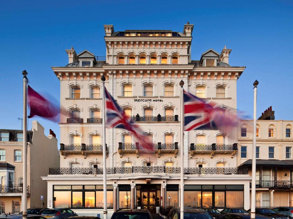 a large white building with flags in front of it at Mercure Brighton Seafront Hotel in Brighton & Hove