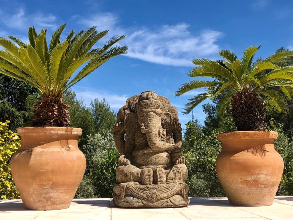 ル・ルレにあるB&B Villa Ganeshの二本の花瓶の間に座る象像