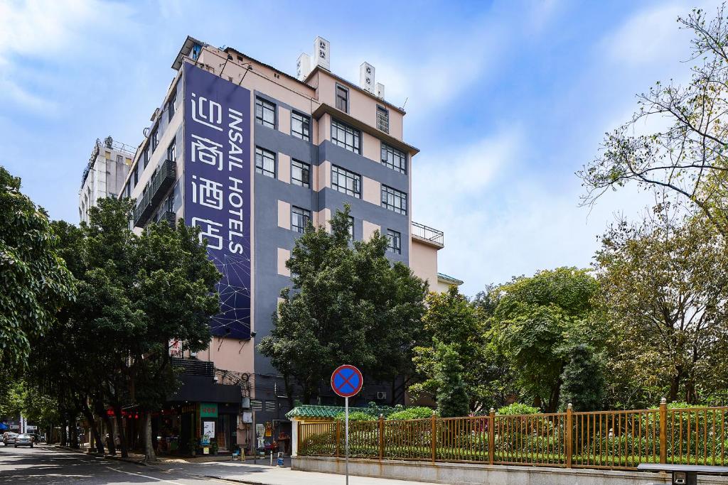 ein Gebäude mit einem blauen Schild auf der Seite in der Unterkunft Insail Hotels Guangzhou XiMenKou Subway Station Branch in Guangzhou