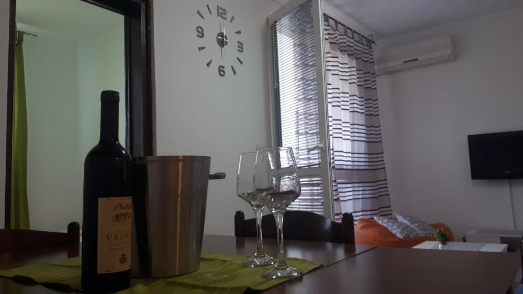 a bottle of wine and a wine glass on a table at Apartment Tijana in Sutomore