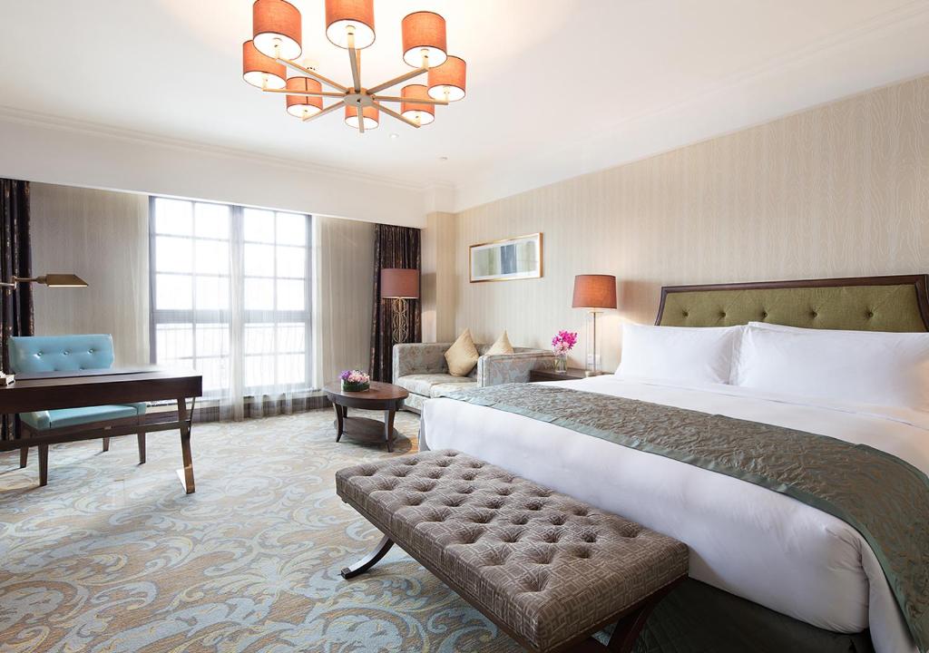 una habitación de hotel con una cama grande y un piano en Meilu Legend Hotel Hangzhou, en Hangzhou