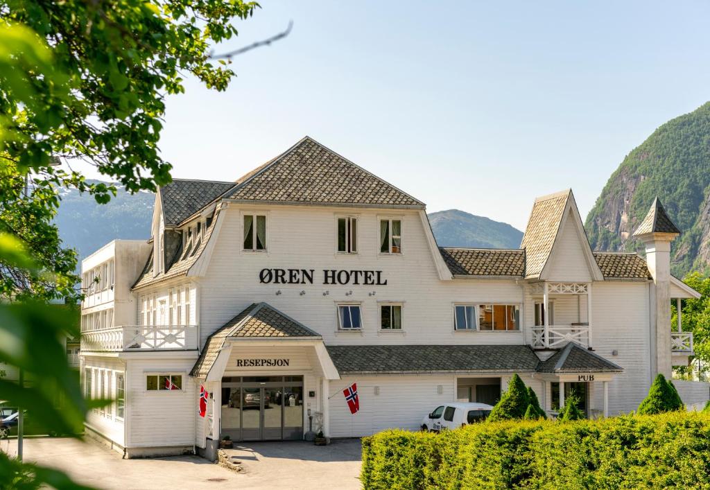 ein großes weißes Gebäude mit einem Schild, das ein offenes Hotel liest in der Unterkunft Øren Hotel in Høyanger