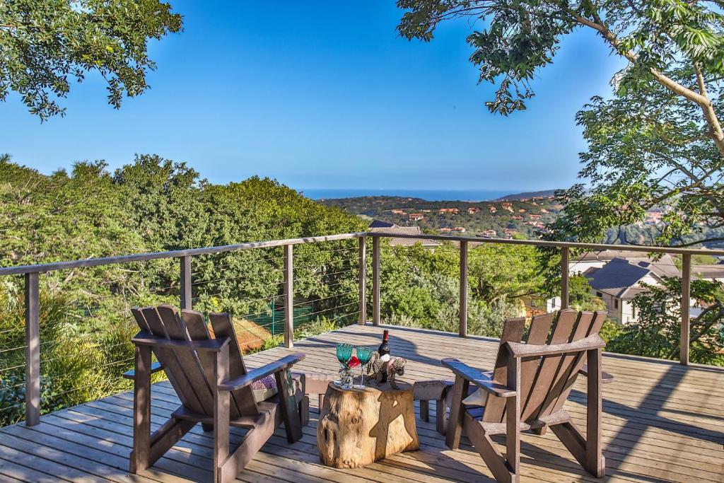 2 sillas y una mesa en una terraza de madera en Kingsley House Chalet, en Ballito