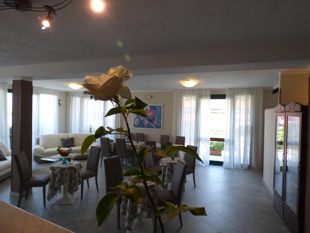 a living room with a table and a flower at Hotel Turandot in Torre del Lago Puccini