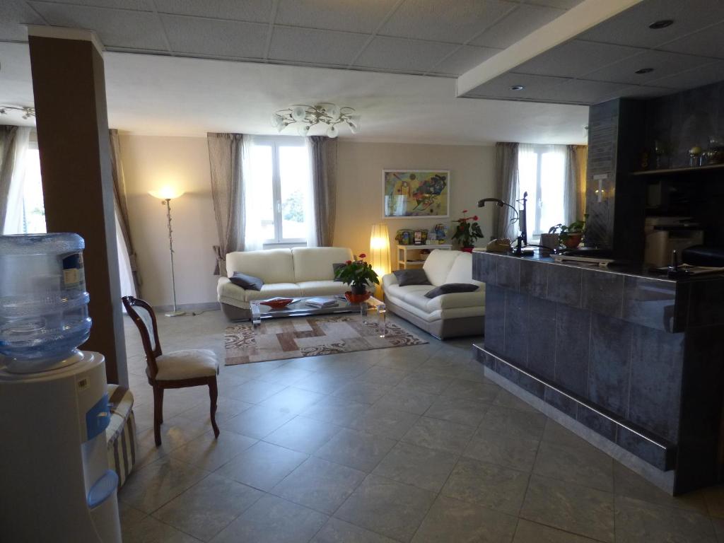 a living room with a couch and chairs and a kitchen at Hotel Turandot in Torre del Lago Puccini