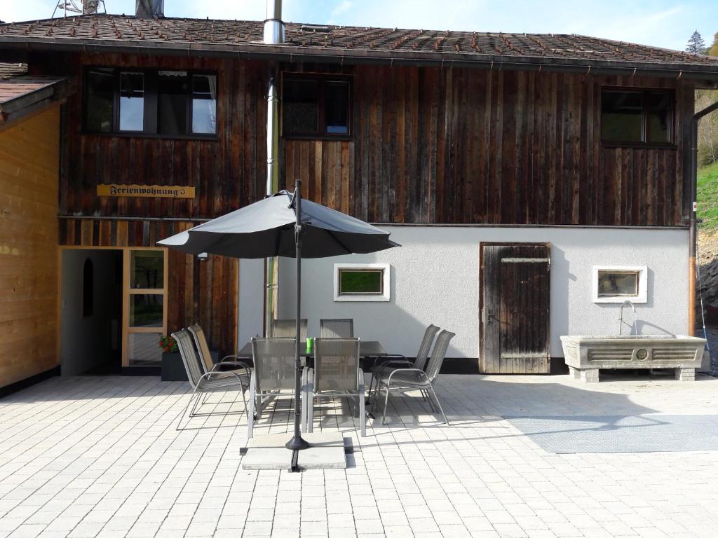 einen Tisch und Stühle mit Sonnenschirm auf einer Terrasse in der Unterkunft Klausberg-Hütte in Bezau