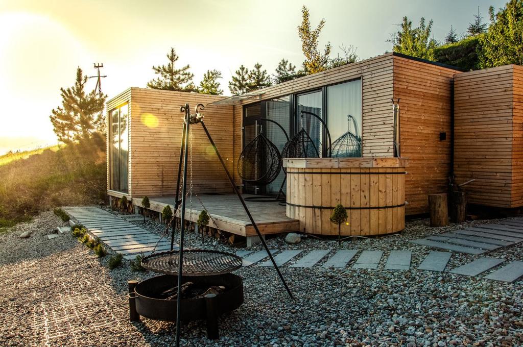 a tiny house with a swing in front of it at Rzepiska Hills in Rzepiska