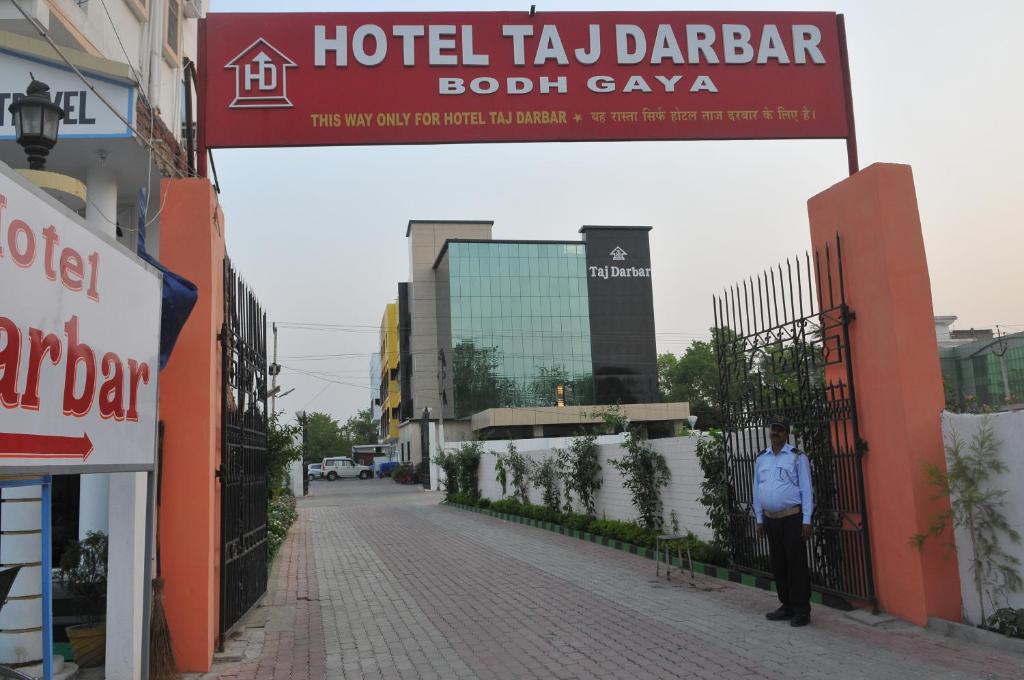 una persona in piedi su una strada di fronte a un hotel tajadjadjadoti di Hotel Taj Darbar a Bodh Gaya
