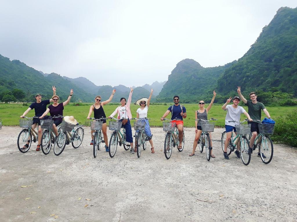 a group of people riding bikes on a dirt road at Calypso Cruises in Ha Long