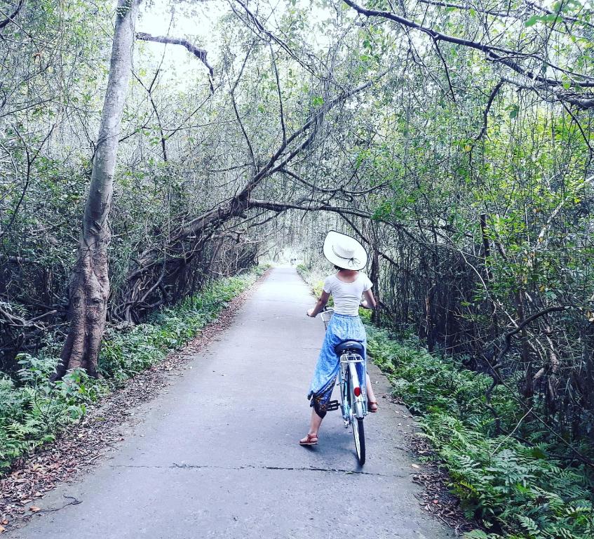 a young girl riding a bike on a path at Calypso Cruises in Ha Long