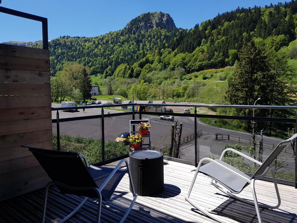 a deck with chairs and a view of a mountain at C4 - Résidence La Montille in Le Mont-Dore