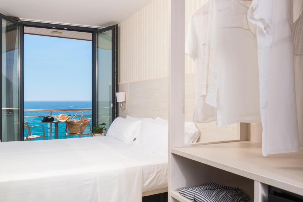 a bedroom with a view of the ocean at Hotel Marsol in Lloret de Mar