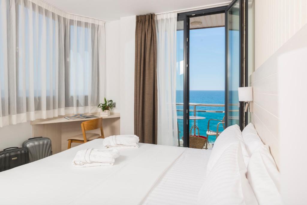 a hotel room with a bed and a view of the ocean at Hotel Marsol in Lloret de Mar